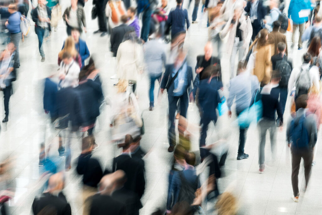 Fólk á ferð í stórum sal, myndin er óskýr (blurruð) þannig að ekki sést í andlit.