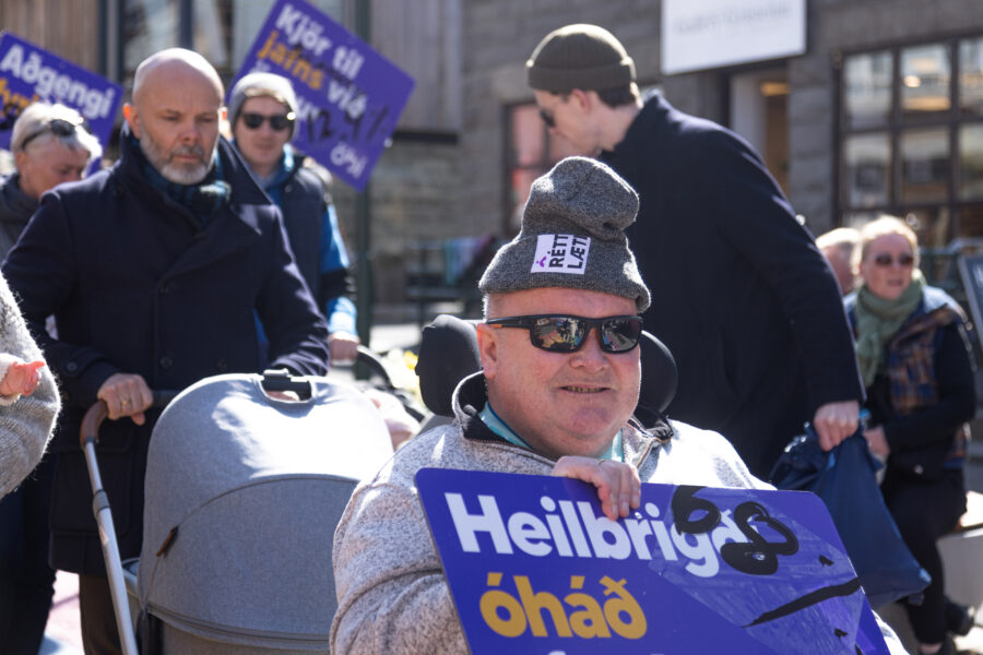 Guðjón, formaður MND félagsins með skilti sem á stendur Heilbrigði óháð efnahag