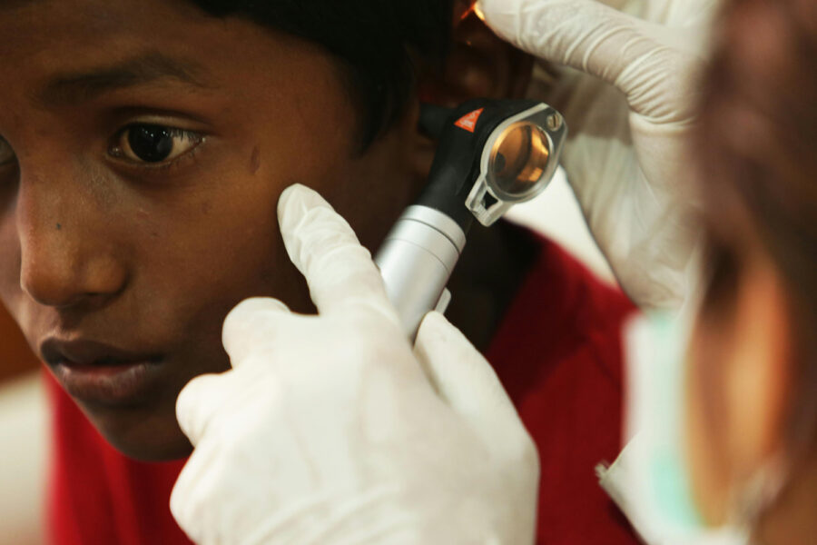 „Heilbrigðisstarfsmaður skoðar eyra á barni með eyrnasjá.“