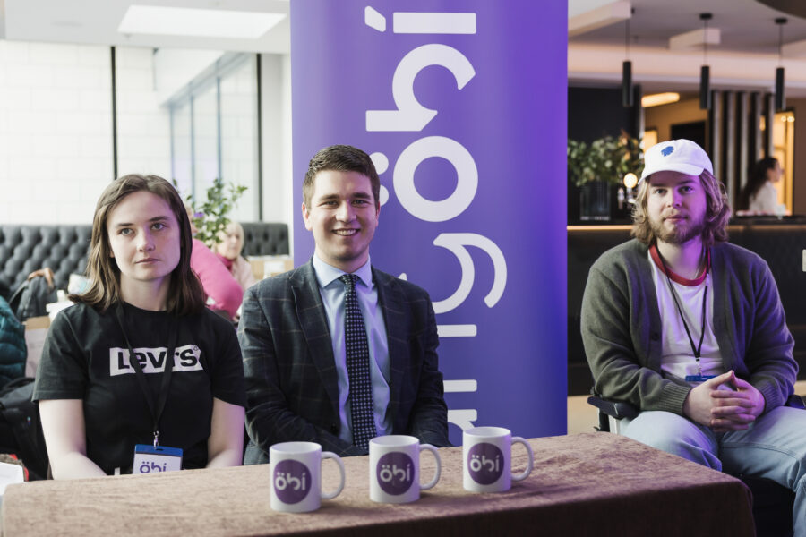 Eiður Welding formaður UngÖBÍ ásamt tveimur úr hónum. ÖBÍ-merktir bollar á borði. og merki UngÖBÍ á fána í bakgrunni.