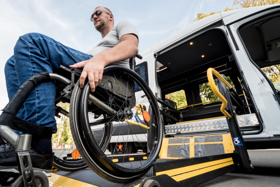 Maður að fara úr hjólastólalyftu úr bíl.
